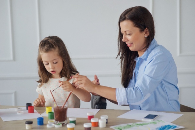 Mamá e hija pintando con témperas en papel